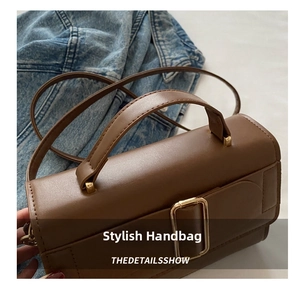 Detailed close-up of a brown vintage leather handbag with a golden square buckle accent