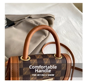 Detail of reinforced leather handle with gold hardware on brown checkered handbag