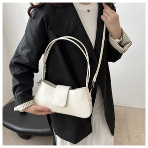 Detail of cream white leather baguette bag featuring buckle closure and double shoulder straps
