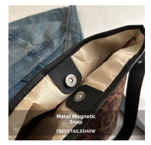 Detail view of the metal magnetic buckle and interior lining on leopard tote bag