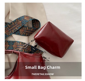 Dettaglio di ciondolo borsa in pelle PU bordeaux con tracolla etnica e gancio silver