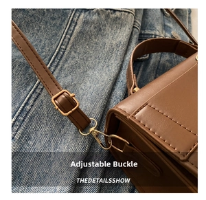 Close-up of adjustable strap buckle and gold lobster clasp on dark brown crossbody bag