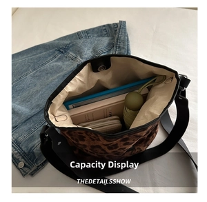 Macro detail showing large capacity interior of leopard print tote bag with daily items