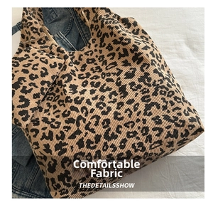 Détail du cabas en velours côtelé imprimé léopard avec texture et pochette assortie