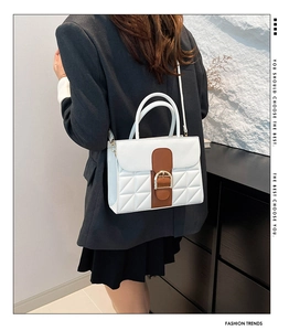 Détail du sac en cuir matelassé blanc avec sangle marron et boucle dorée