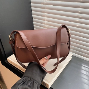 Minimalist dark brown matte leather shoulder bag with flap closure and adjustable strap