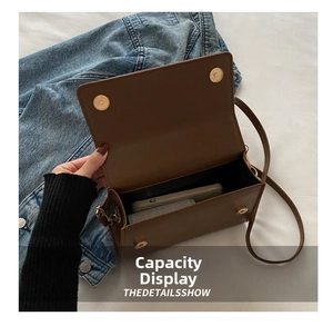 Internal view of brown leather square handbag showing capacity for phone and daily items