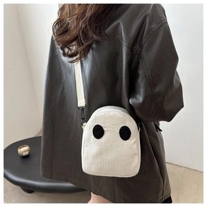 Détail du sac fantôme en velours côtelé blanc avec yeux noirs et fermoir métal
