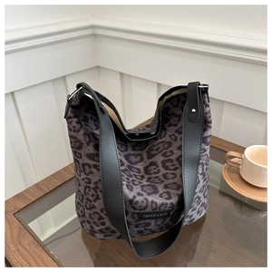 Detail of leopard print hobo tote bag with black strap on a coffee table