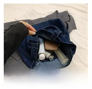 Spacious interior of dark blue denim tote bag with zipper closure and pocket space