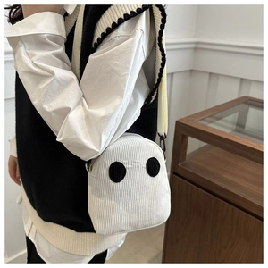 Détail du sac fantôme en velours côtelé blanc montrant la texture douce et le visage