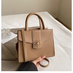 Détail du sac à main minimaliste avec boucle florale dorée et texture en similicuir lisse