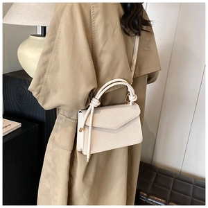 Detail of cream white textured handbag with honeycomb pattern and braided rope handle