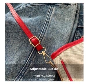 Detail of adjustable red leather shoulder strap with gold metal buckle on canvas bag