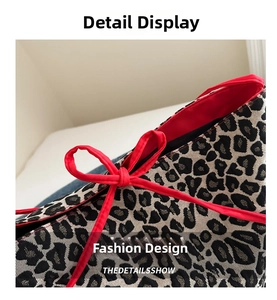 Detailed macro view of leopard print fabric texture with vibrant red ribbon trim accent