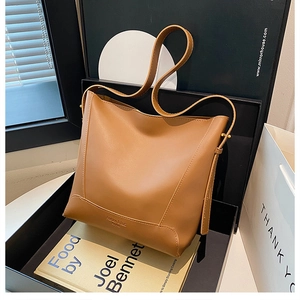 Detail view of brown vintage bucket bag with elegant metal hardware in a stylish setup