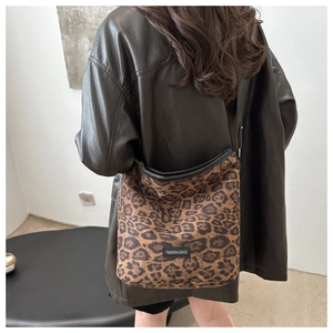 Detail of leopard print bucket bag with plush texture and stylish fashion logo patch