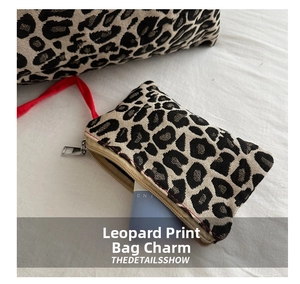 Detail of leopard print canvas tote bag with mini coin purse and red lanyard accent