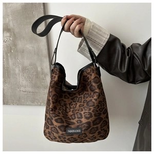 Close-up of leopard print bucket bag with black leather strap and fashion logo label