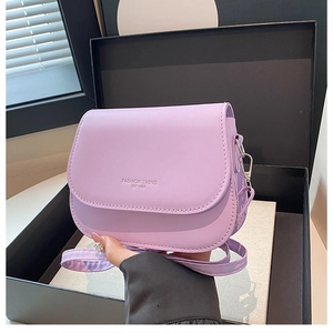 Close-up of lavender saddle bag featuring silver metal hardware and fashion trend text
