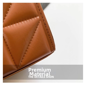 Gros plan sur la texture en cuir matelassé marron avec surpiqûres de qualité d'un sac