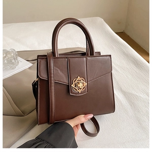 Détail d'un sac à main marron en cuir mat avec un élégant fermoir pétale doré