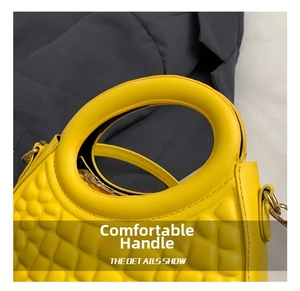 Detail of bright yellow crescent bag featuring quilted texture and round handle