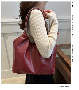 Close-up of red large-capacity tote bag in textured faux leather with shoulder strap
