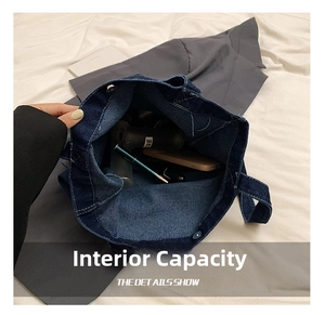 Detail view of the spacious inner compartment of the blue denim tote bag with daily items