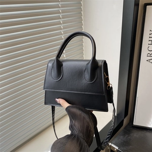Minimalist black matte leather small square handbag with golden hardware and shoulder strap