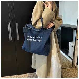 Détail du grand sac cabas en jean avec slogan Less Mondays More Sundays brodé