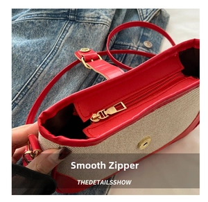 Detail of smooth golden metal zipper closure on contrast color woven shoulder bag