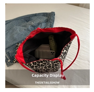 Detailed interior of leopard print bucket bag showing red lining and large storage capacity