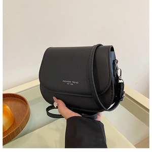 Detail of a black semi-circular saddle bag with white lettering and adjustable strap