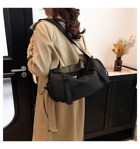 Detail showing high-density nylon black cylinder crossbody bag with adjustable strap