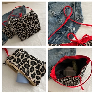 Detail view of leopard print tote bag with contrasting red shoulder straps and matching pouch