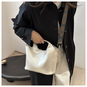 Detailed shot of pearlescent white tote bag with ethnic print wide shoulder strap
