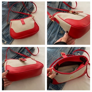 Detail view of red and beige canvas handbag showing interior space and metal buckle
