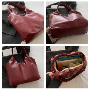 Detail view of burgundy pleated tote bag showing large capacity for books and umbrella