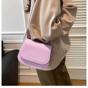 Lavender leather saddle bag with Fashion Trend lettering shown in a stylish side-carry view