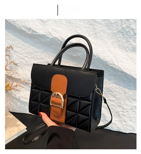 Détail du sac à main en cuir PU noir et marron avec matelassage et boucle dorée