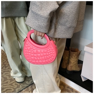 Detailed view of pink quilted half-moon handbag with 3D diamond texture and handle
