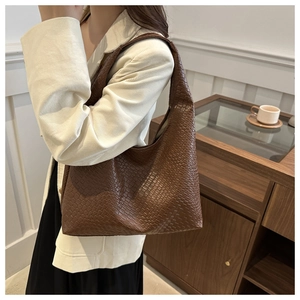 Détail de la texture tissée marron foncé du grand sac cabas avec bandoulière large