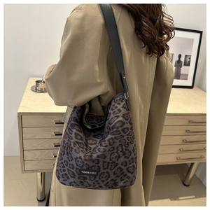 Detail of grey leopard print suede bucket bag with leather strap and fashion label