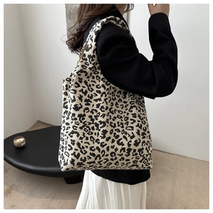 Sac fourre-tout en velours côtelé léopard porté avec un blazer noir chic