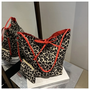 Detail view of leopard print tote bag with orange lining and matching zipper pouch