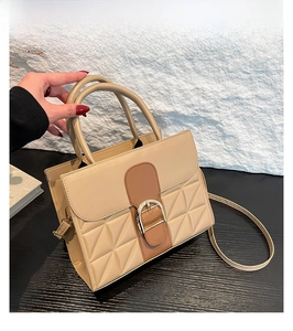 Détail du sac à main kaki avec texture crocodile, boucle dorée et surpiqûres élégantes