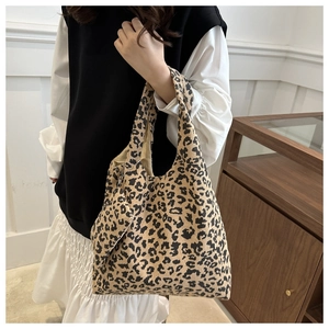 Gros plan du sac fourre-tout en velours léopard avec sa mini pochette zippée assortie