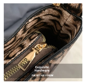 Dettaglio ravvicinato della cerniera dorata e fodera leopardata su borsa a tracolla vintage