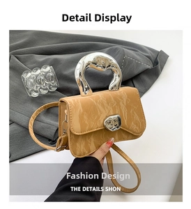 Detail of caramel crossbody bag featuring irregular silver metal handle and pleated texture